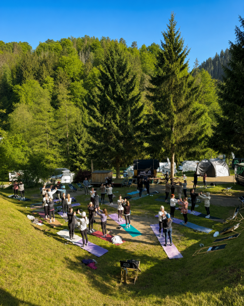 Marlon Blatz von Ganesha’s room leitet Firmenyoga mit einer großen Outdoor-Yogagruppe bei einem Jack Wolfskin Retreat in der Natur.